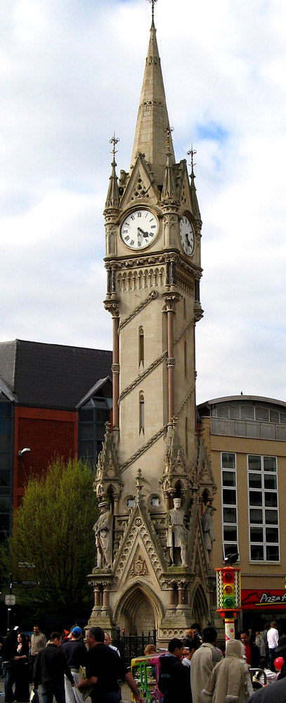 The Haymarket Memorial Clock Tower in Leicester, with people at its base